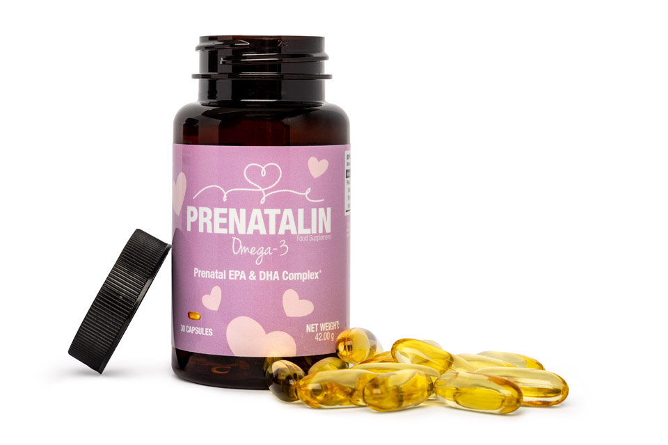 Prenatal vitamin supplement bottle with Quatrefolic (bioavailable folate) label 
displayed with loose capsules on concrete surface, representing quality prenatal 
supplementation